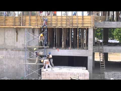 Cadena humana subiendo ladrillos tres pisos